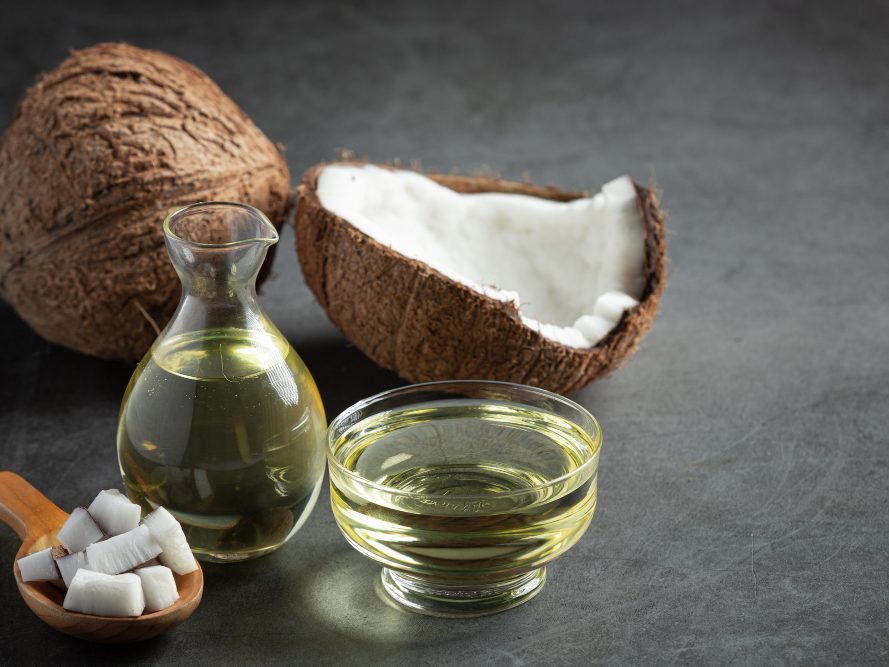 Coconut oil in a jar and a bowl for scalp care hot oil treatment